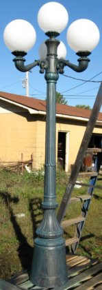 cast aluminum victorian street lamp with three arms and four lights and a verdi gris finish